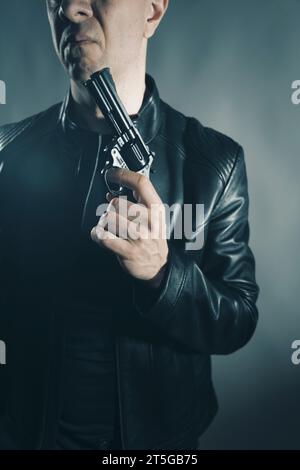 Schwarze Lederjacke Mörder Detective Spion Mörder Attentäter mit Gewehrporträt Foto. Stockfoto
