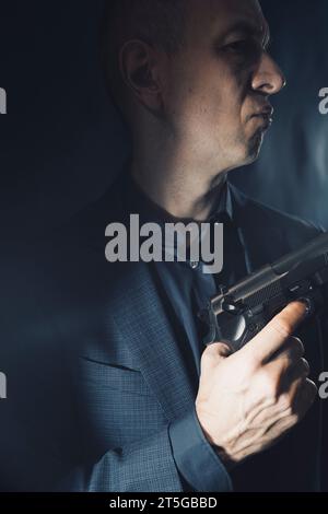 Söldner-Killer Spion-Attentäter Detective mit Pistole Portrait Studio Foto gemacht. Stockfoto