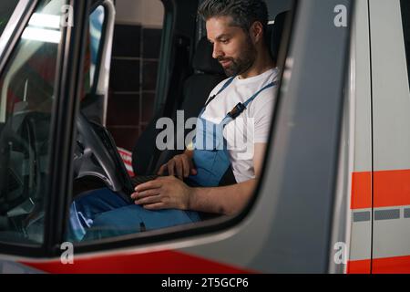 Kfz-Techniker, der einen Computerdiagnosetest am Kundenfahrzeug durchführt Stockfoto