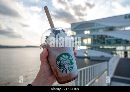 Seoul, Südkorea - 14. Juli 2022: Handgehaltener Becher Minzschokolade CIP, gemischt vor dem Seoul Wave Art Center Gebäude, schwimmendes Starbucks auf Ha Stockfoto