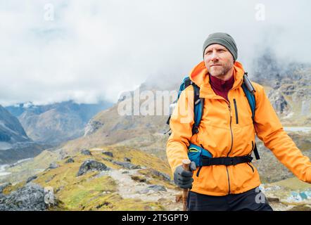 Porträt eines kaukasischen Mannes mit Rucksack und Wanderstöcken auf der Makalu Barun Park Route in der Nähe von Khare. Mera Peak Klettern Akklimatisierung aktiv Walk. Zurück Stockfoto