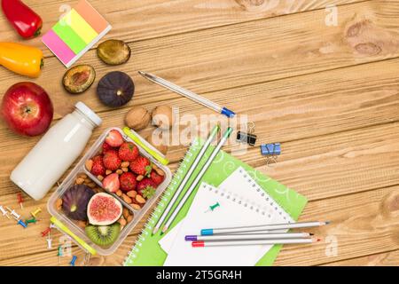 Nahrhafte Lunchbox aus Früchten, Beeren und Nüssen. Eine Flasche Wasserjoghurt. Heller Holztisch. Flache Lagen. Kopierbereich Stockfoto