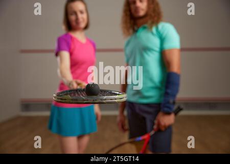 Glückliches Paar posiert für die Kamera nach dem Squashspiel Stockfoto