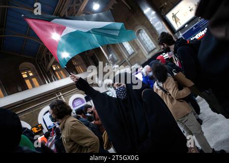 Eine Frau schwenkt während des Protestes eine palästinensische Flagge am Bahnhof Charing Cross. Tausende von Demonstranten versammelten sich in Solidarität mit dem palästinensischen Volk, während sich der Konflikt zwischen Israel und Gaza nach dem beispiellosen Angriff der Hamas Anfang Oktober weiter verschärft. Stockfoto