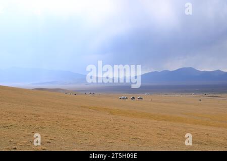 Riesige kirgisische Steppe in der Nähe des Songkol-Sees. Berge im Hintergrund in Kirgisistan Stockfoto