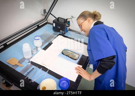 Papierwerkstatt der Klassik-Stiftung der Anna-Amalai-Bibliothek in Weimar, Thüringen. Foto vom 02.11.2023: Laura Voelkel Völkel, Restaurierungswissenschaftlerin und Leiterin der Papierwerkstatt, bringt mit einem Airbrush-Verfahren die Nanocellulose auf die beschaedigten Seiten auf, dass das Papier so weit stabilisiert soll, dass es multispektral digitalisiert werden kann in der Restaurierungswerkstatt werden mehr als 1, 5 Millionen Buchseiten und Tausende Dokumente restauriert. Viele von ihnen fielen dem Feuer der Bibliothek im Jahr 2004 zum Opfer. Siehe epd-Bericht vom 05.11.2023 EDITORIAL Stockfoto