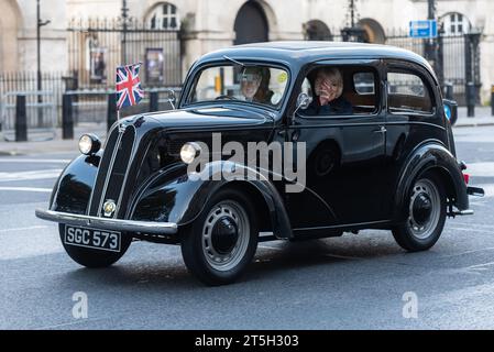 Westminster, London, Großbritannien. November 2023. Die Rennstrecke von London nach Brighton ist das am längsten laufende Motorrennen der Welt. Das erste Rennen fand 1896 statt, um die Verabschiedung des Gesetzes zu feiern, das es „leichten Lokomotiven“ ermöglichte, mit Geschwindigkeiten von mehr als 4 km/h zu fahren. Fahrzeuge, die an der Veranstaltung teilnehmen, müssen vor 1905 gebaut worden sein. Die Fahrzeuge fuhren bei Sonnenaufgang vom Hyde Park durch London, bevor sie in Richtung Süden fuhren. Ford populäres Auto mit Masken von König Karl III. Und der Königin Stockfoto