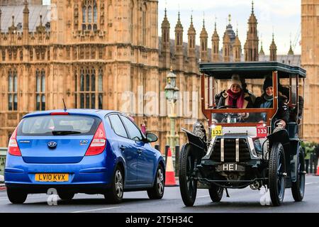 London, UK, 05. November 2023. Ein 1902er Napier, jetzt mit Schutzdach, trifft auf eine moderne Hyundai an der Westminster Bridge. Der RM Sotheby's London to Brighton Veteran Car Run, eines der am längsten laufenden Motorsportveranstaltungen weltweit, startet im Hyde Park und überquert die Westminster Bridge, bevor die Autos weiter zur Küste von Sussex fahren. Ein teilnehmendes Fahrzeug muss vor 1905 sein, um am Rennen teilnehmen zu können. Quelle: Imageplotter/Alamy Live News Stockfoto