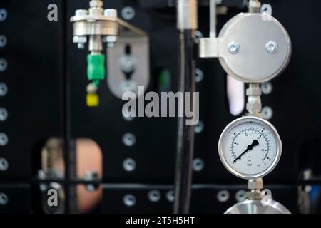 An der Rohrleitung montierte Manometer. Messgeräte zur Druckregelung. Industriekonzept Stockfoto