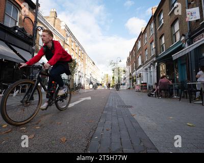 Öffentliche Plätze und Verkehrsberuhigung im Dorf Orford Road Walthamstow London, Großbritannien, mit Radfahrern, die die Straße hinunter fahren Stockfoto