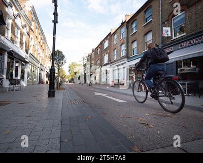 Öffentliche Plätze und Verkehrsberuhigung im Dorf Orford Road Walthamstow London, Großbritannien, mit Radfahrern, die die Straße hinunter fahren Stockfoto