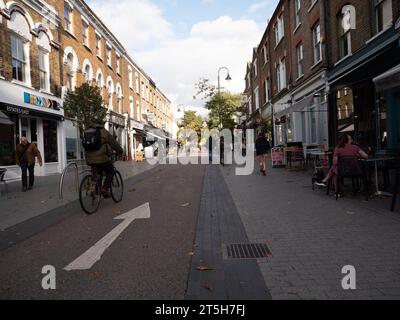 Öffentliche Plätze und Verkehrsberuhigung im Dorf Orford Road Walthamstow London, Großbritannien, mit Radfahrern, die die Straße hinunter fahren Stockfoto