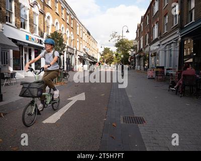 Öffentliche Plätze und Verkehrsberuhigung im Dorf Orford Road Walthamstow London, Großbritannien, mit Radfahrern, die die Straße hinunter fahren Stockfoto