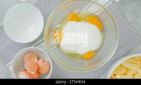 Mischung aus Eiern und Zucker in einer Glasschale. Apfelkuchen Rezept Stockfoto