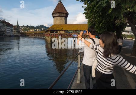 Luzern, Schweiz, 26. August 2023 - Jung asiatische Touristen machen Fotos vor der Kapellbrücke Stockfoto