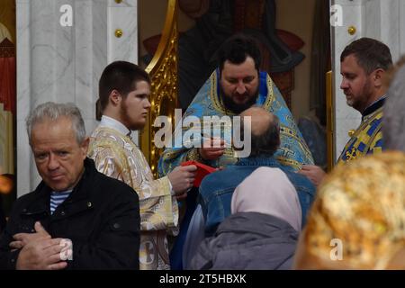 Orthodoxe christliche Priester und Gläubige werden während der Eucharistiefeier nach dem Gottesdienst in der Kirche der Heiligen Gleichgesinnten Olga in Zaporischschschiha gesehen. Der 4. November ist der Festtag der kasanischen Ikone der Mutter Gottes. Die kasanische Ikone der Mutter Gottes ist eine verehrte wundersame Ikone der Mutter Gottes, die 1579 in Kasan (Russland) erschien. Eine der verehrtesten Ikonen der Russisch-Orthodoxen Kirche. Die kasanische Ikone der Mutter Gottes wird für spirituelle Erleuchtung gebetet, einschließlich der Suche nach den Rechten Stockfoto