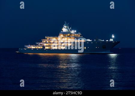 Die 107 m lange Superyacht Ulysses vor Anker bei Antibes bei Nacht zeigt alle Innenbeleuchtung und Deck. Stockfoto