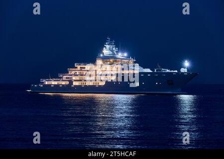 Die 107 m lange Superyacht Ulysses vor Anker bei Antibes bei Nacht zeigt alle Innenbeleuchtung und Deck. Stockfoto