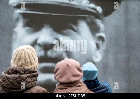 Moskau, Russland. November 2023. Besucher eines Freilichtmuseums auf dem Roten Platz in Moskau sehen die historische Chronik auf der Großleinwand; das Museum wurde anlässlich des 82. Jahrestages der historischen Parade des Roten Platzes am 7. November 1941 eröffnet, als Truppen der Roten Armee an die Front des Zweiten Weltkriegs aufbrachen, um Moskau vor den Nazi-Truppen zu verteidigen. Stockfoto