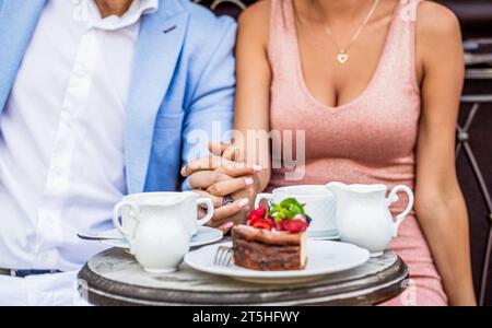 Romantisches Paar, das die Hände hält. Ein Paar trinkt Kaffee im Café. Kaffee trinken. Glückliches romantisches Paar, das in einem Café sitzt und Kaffee trinkt. Paare Stockfoto