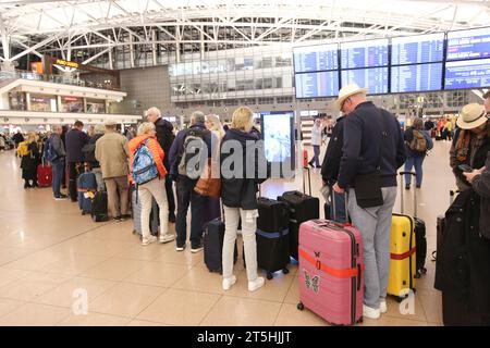 Hamburg, Deutschland. November 2023. Reisende stehen in Terminal 1 am Flughafen Hamburg in der Schlange. Tausende von Fluggästen waren von der Geiselnahme am Hamburger Flughafen am Samstagabend betroffen und Hunderte von Flügen wurden storniert. Quelle: Bodo Marks/dpa/Alamy Live News Stockfoto