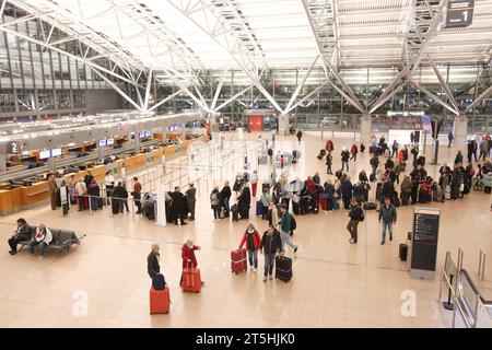 Hamburg, Deutschland. November 2023. Reisende befinden sich unterwegs oder warten in Terminal 1 am Flughafen Hamburg. Tausende von Fluggästen waren von der Geiselnahme am Hamburger Flughafen am Samstagabend betroffen und Hunderte von Flügen wurden storniert. Quelle: Bodo Marks/dpa/Alamy Live News Stockfoto