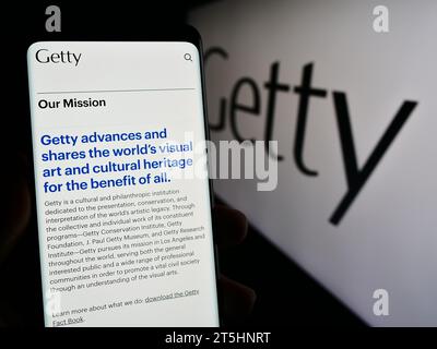 Person, die ein Handy hält, mit Webseite der US-Kunststiftung J. Paul Getty Trust vor dem Logo. Konzentrieren Sie sich auf die Mitte des Telefondisplays. Stockfoto