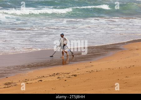 Sydney Australien Mann mit einem Metalldetektor geht entlang eines verlassenen Newport Beach auf der Suche nach Wertsachen und Schatztruhe, NSW, Australien Stockfoto