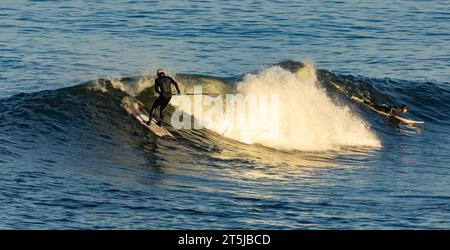 Surfer, die große Wellen für Wassersport genießen Stockfoto