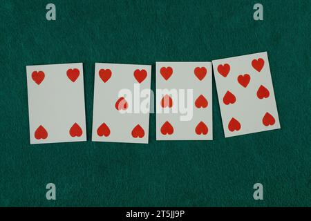 Spielkarte der alten Westära auf grünem Spieltisch. 4,5,6,7 der Herzen. Stockfoto