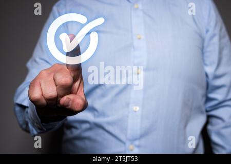 Nicht erkennbare kaukasische Hand mit einem Finger, der die Luft berührt, wo ein virtuelles Häkchen in einem Kreis erscheint. Stockfoto