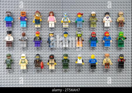 Nova Bana, Slowakei - 5. November 2023 : Lego-Minifiguren an der Wand. LEGO® Minifiguren auf Lego Grundplatten in Reihe. Stockfoto