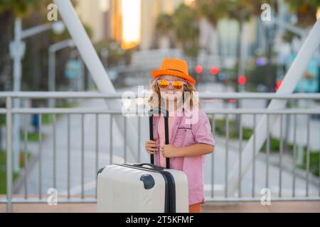 Porträt eines Modekindes mit Gepäck, Koffer, die in Urlaub gehen. Reise-Lifestyle. Träume von Reisen, Abenteuern, Urlaub. Ein kleiner Touristenspaziergang Stockfoto