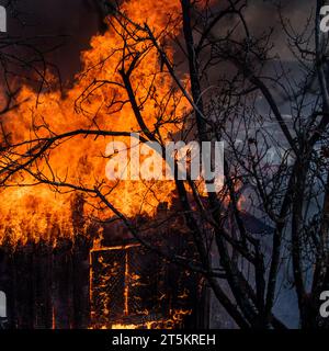 Feuerwehrhaus. Brennendes Gebäude. Offenes Feuer. Brennendes Zuhause. Einfamilienhaus komplett zerstört durch Flammen. Hausfeuer. Brennen Stockfoto
