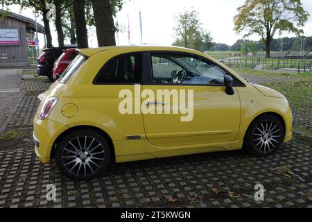 Hardenberg, Niederlande - Oktober 2023. Ein gelber Fiat 500 steht in der Nähe des Flusses Vecht Stockfoto