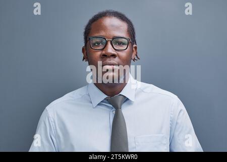 Porträt eines afro-amerikanischen jungen Mannes auf grauem Hintergrund Stockfoto