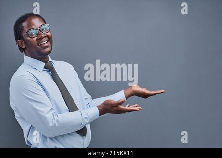 Junger afroamerikaner überrascht, seine Hand zur Seite zu zeigen Stockfoto