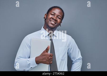 Porträt eines afro-amerikanischen jungen Mannes auf grauem Hintergrund Stockfoto