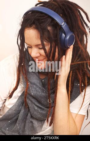 Alternative Bohemian Frau mit Dreadlocks und Kopfhörern Inhalt und Lächeln Stockfoto