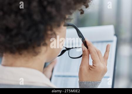 Frau im Büro, die Papierdokumente durchsucht Stockfoto