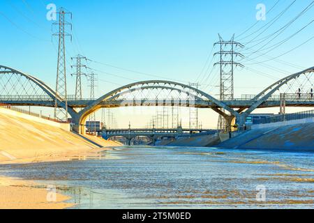 Blick auf die 6th Street Bridge, die sich anmutig über den LA River vor der Kulisse von Stromleitungen erhebt. Stockfoto