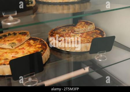 Verschiedene leckere Quiches auf der Theke im Laden Stockfoto