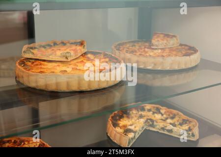 Verschiedene leckere Quiches auf der Theke im Laden Stockfoto