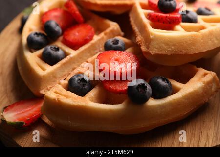 Leckere belgische Waffeln mit frischen Beeren auf Holzbrett, Nahaufnahme Stockfoto