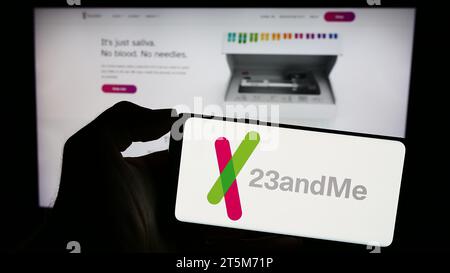 Person, die ein Mobiltelefon mit dem Logo des amerikanischen Biotechnologie-Unternehmens 23andMe Inc. Vor der Business-Webseite hält. Schwerpunkt auf dem Display des Telefons. Stockfoto