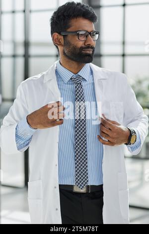 Porträt eines lächelnden männlichen Arztes, der in einem Krankenhausgang steht Stockfoto