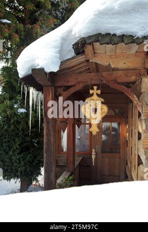 Altes Holzhaus in einer wunderschönen Winterlandschaft. Riesige Eiszapfen hängen vom Dach. Zakopane, Polen Stockfoto