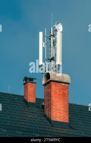 Basisstation für Mobilfunk und Signalverstärker-Antenne auf dem Dach des Gebäudes, Telekommunikationstechnik, selektiver Fokus Stockfoto