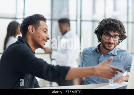 Geschäftsleute in einem Meeting, die zusammenarbeiten, kommunizieren und positive Teamarbeit zeigen. Stockfoto