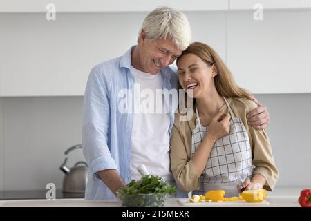 Glückliche, reife Eltern und Erwachsene Kinder, die ein Familienessen kochen Stockfoto